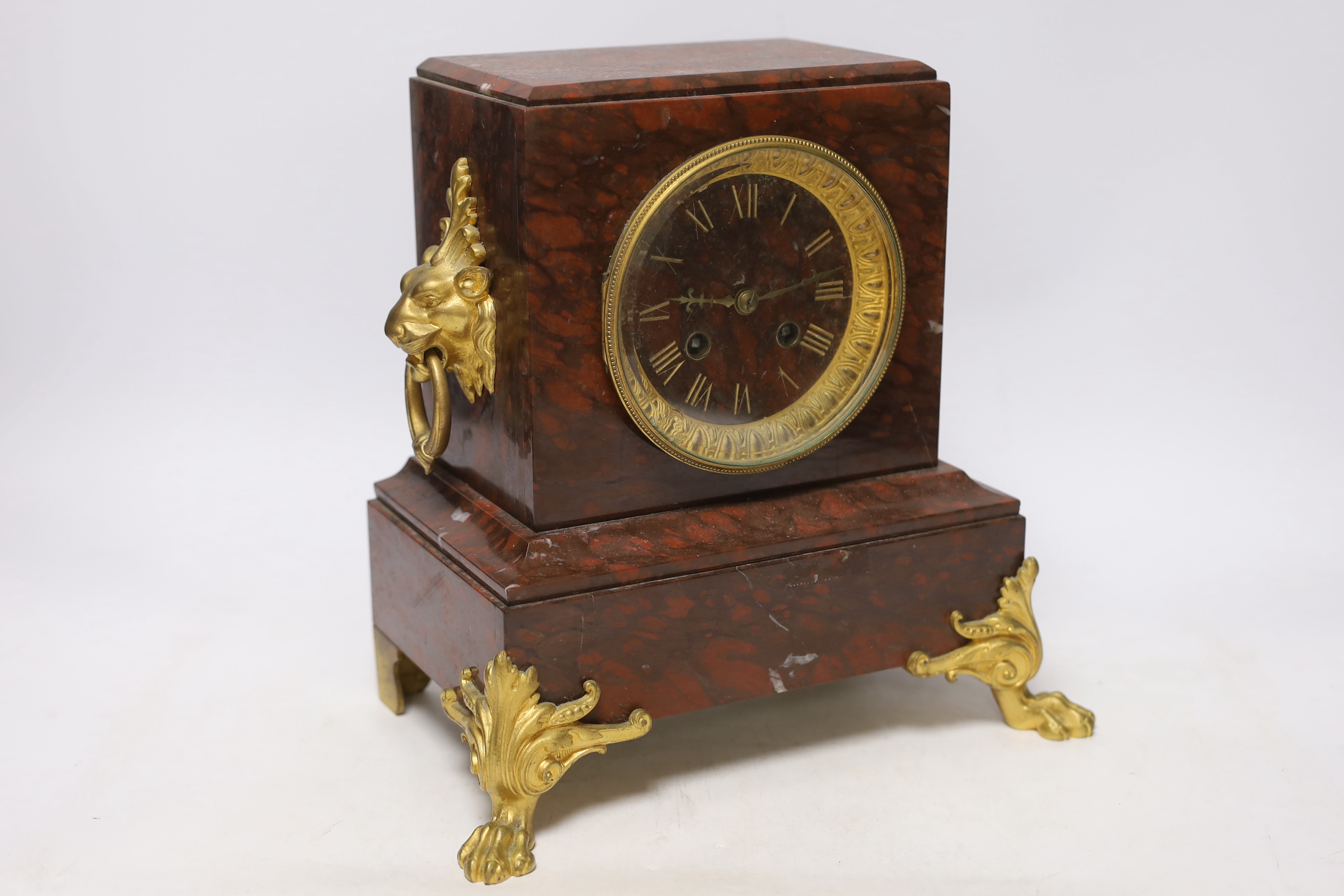 A late 19th century French rouge marble and ormolu clock garniture, 31cm